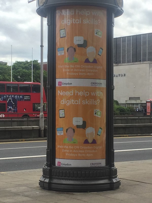 An image of street furniture with a promotional poster for digital skills